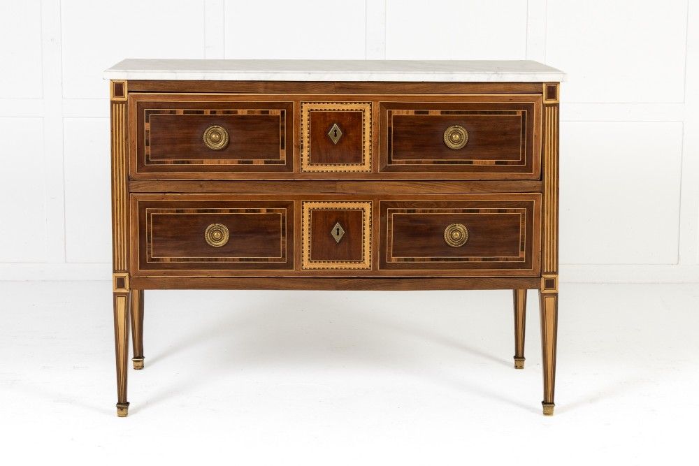A pair of 18th-century Italian Neoclassical chests of drawers featuring geometric wood inlays, brass ring handles, light marble tops, and tapered square legs. View II