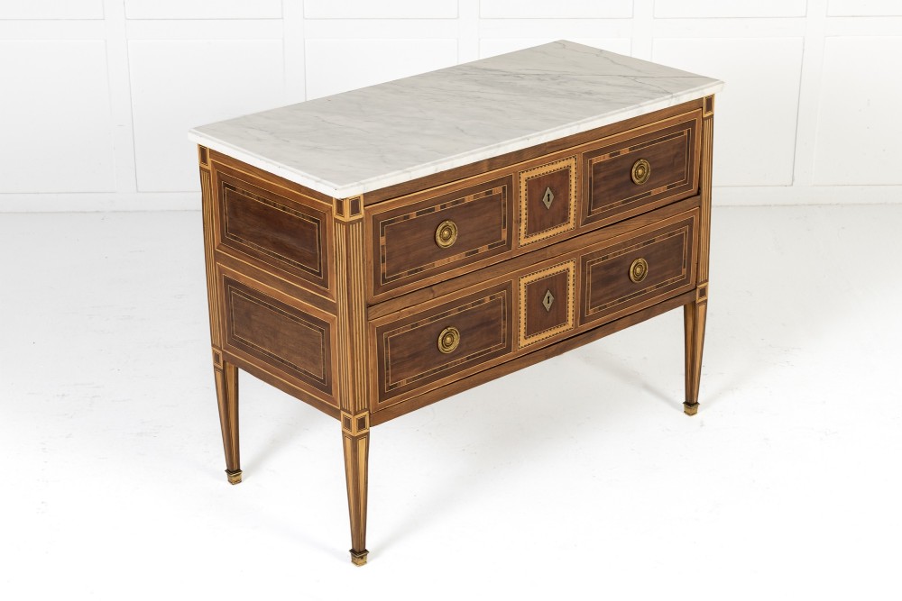 A pair of 18th-century Italian Neoclassical chests of drawers featuring geometric wood inlays, brass ring handles, light marble tops, and tapered square legs. View IV