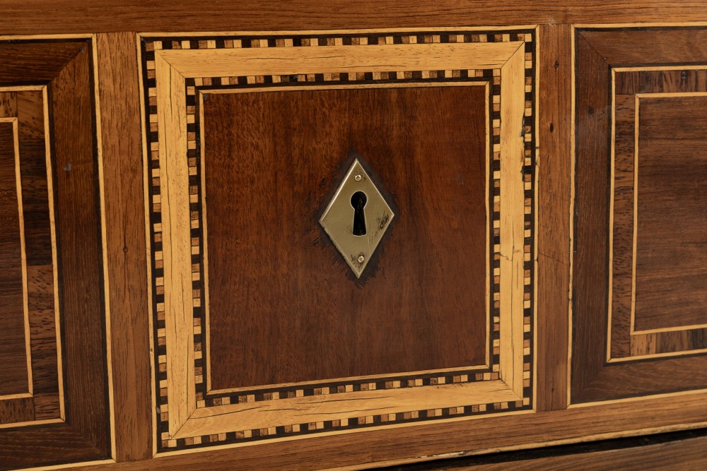 A pair of 18th-century Italian Neoclassical chests of drawers featuring geometric wood inlays, brass ring handles, light marble tops, and tapered square legs. View X