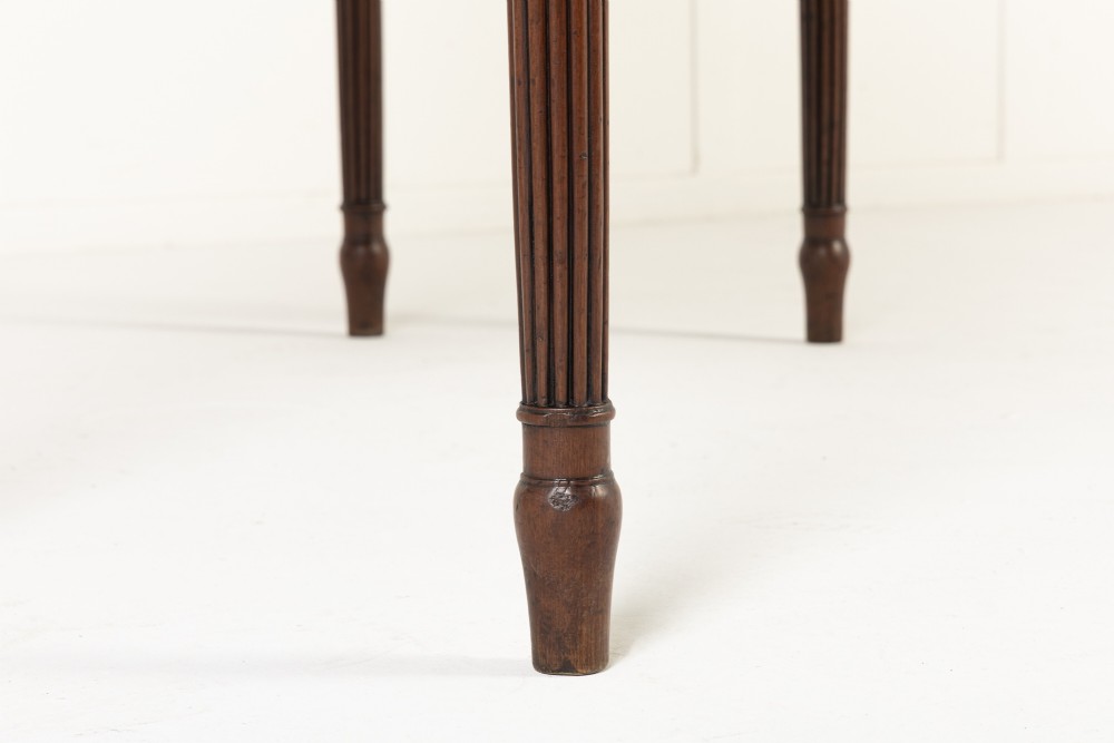 A close-up detail of a 19th-century mahogany serving table frieze featuring dark ebony stringing inlay with a central diamond motif. View VI