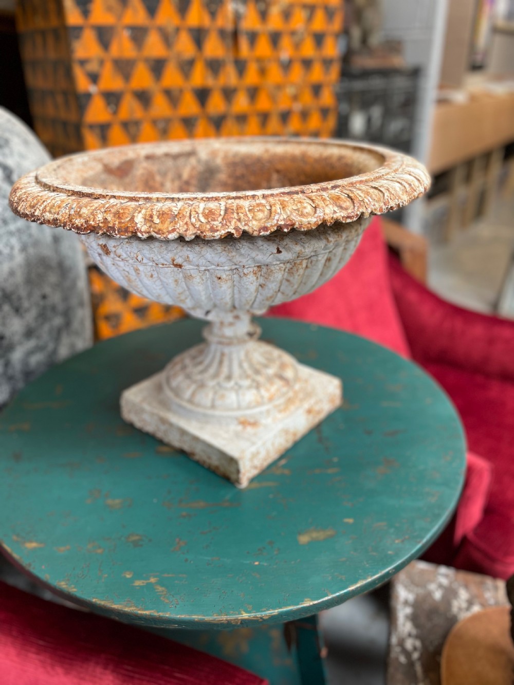 A 19th-century cast iron Ferndale garden urn featuring a gadrooned bowl and fluted rim with a distressed cream painted finish on a square pedestal base. View II