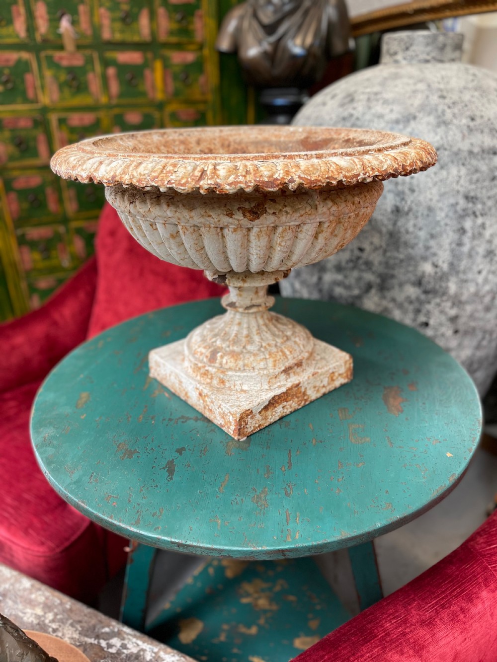 A 19th-century cast iron Ferndale garden urn featuring a gadrooned bowl and fluted rim with a distressed cream painted finish on a square pedestal base. View III