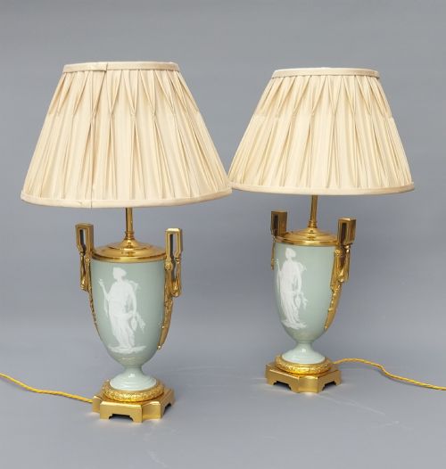 fig 2. A pair of 19th-century French celadon green porcelain urn table lamps featuring white pate-sur-pate classical relief figures, gilt bronze handles and bases, and cream pleated lampshades.