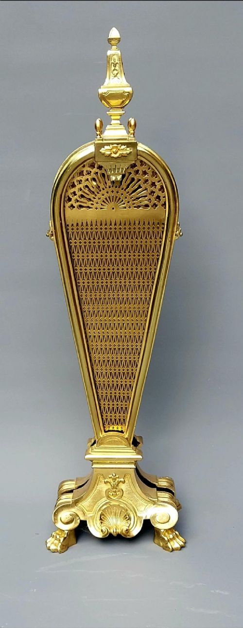 fig 3. A French gilt bronze fan-shaped fire screen featuring folding filigree mesh panels, an ornate central standard with a dark mask, and a cast shell pedestal base.