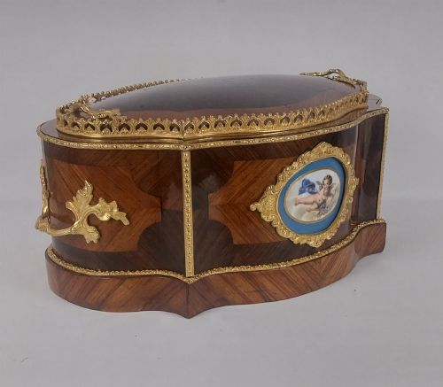 fig 1. A late 19th-century French serpentine table jardiniere constructed from kingwood and tulipwood parquetry, featuring gilt bronze mounts and a central oval hand-painted porcelain medallion depicting a cherub.