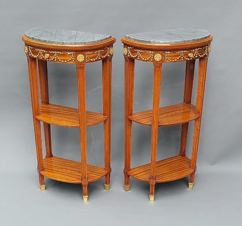 A pair of semi-circular French satinwood etagere tables featuring grey marble tops, gilt bronze garland mounts, and two lower tiers. View III