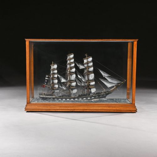 fig 1. A fully rigged model of the tea clipper ship Glengarry displayed in full sail on a simulated sea base inside a rectangular glazed oak case with a brass nameplate.