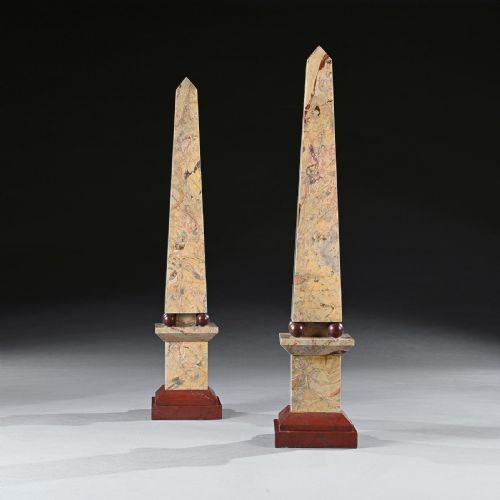 fig 3. A pair of tall Portasanta marble obelisks featuring cream and brown veining, resting on spherical red marble feet and stepped Rosso Antico bases.