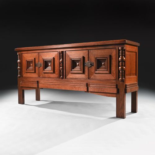 fig 1. A mid-20th-century French Art Deco solid oak sideboard featuring four cabinet doors with raised geometric pyramid motifs and turned wood accents.