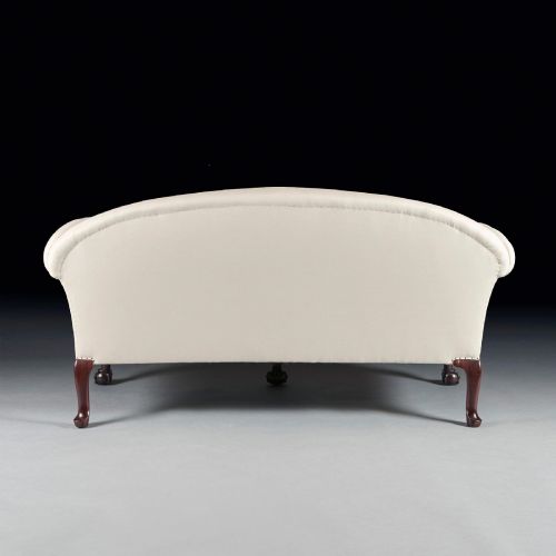 fig 2. A two-seater sofa upholstered in off-white calico fabric featuring carved dark mahogany cabriole legs with ball and claw feet.