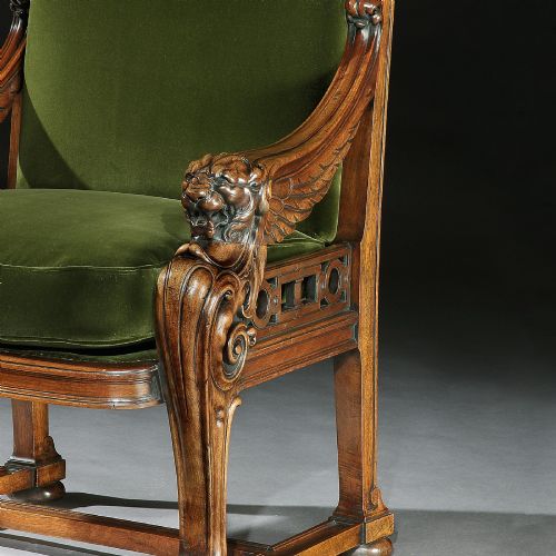 fig 3. A carved wood armchair with green velvet upholstery, winged lion head armrests, carved claw feet, and a decorated crest rail.