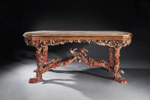 fig 1. An ornate Italian centre table featuring a sunburst pattern onyx top supported by a sculpted polychrome and gilded wooden frame shaped like grapevine branches.