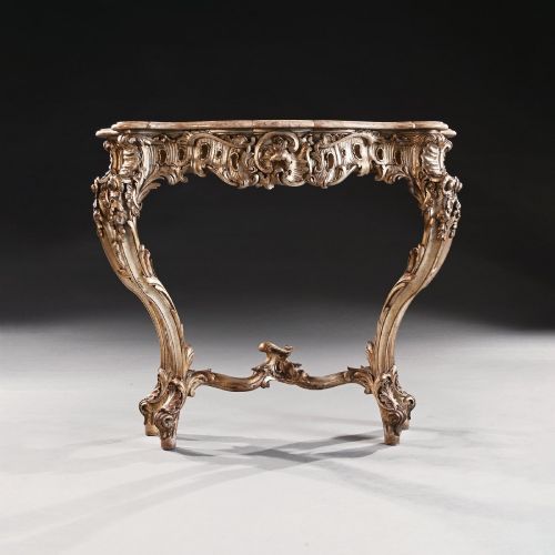 fig 1. A 19th-century Italian silver gilt console table featuring elaborate Rococo carvings, cabriole legs, a central stretcher, and a contoured marble top.