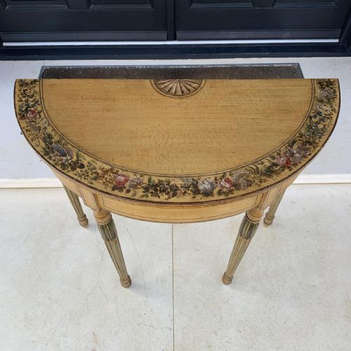 fig 4. A Georgian painted demi-lune pier table featuring a semi-circular top with polychrome painted borders and four fluted tapered legs.