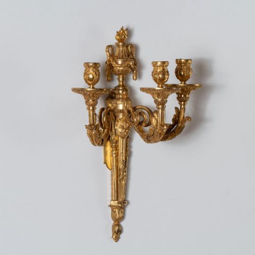 fig 4. A set of four French Louis XV style gilded bronze wall lights, each featuring three scrolling foliate arms supporting candle sockets and an urn finial backplate.