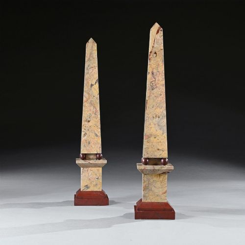 fig 3. A pair of tall, veined marble obelisks carved from Portasanta and Rosso Antico marble with polished spherical details on tiered square bases.