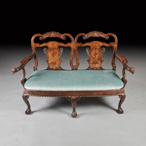 fig 1. A late nineteenth-century walnut twin chair back sofa featuring vasiform splats, shell carving, cabriole legs with claw and ball feet, and a teal upholstered seat.