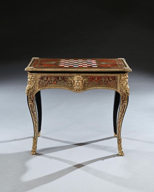 fig 1. A George IV period Boulle marquetry games table featuring brass and tortoiseshell inlay, gilt-bronze mounts, cabriole legs, and an inlaid chessboard top.