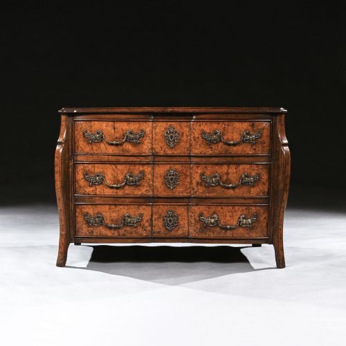 fig 1. An 18th-century French Louis XV provincial commode made from figured burr elm with three drawers and cast brass handles.