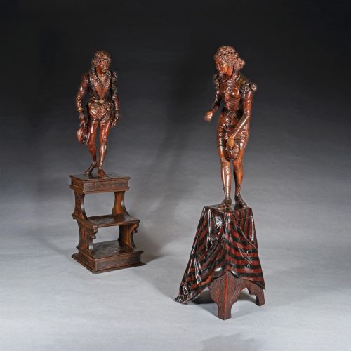 fig 1. A pair of carved brown wood figures depicting Renaissance figures atop detailed wooden bases.