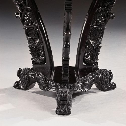 fig 3. A 19th-century Ceylonese octagonal centre table crafted from dark ebony featuring a geometric starburst specimen wood inlaid top and deeply carved pedestal base.
