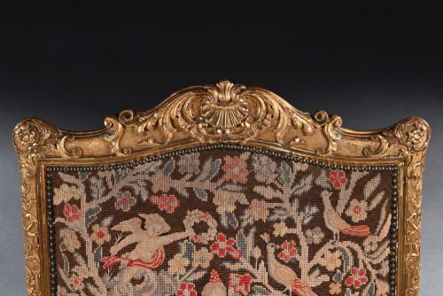 fig 3. An 18th-century French Regence carved giltwood armchair featuring padded open armrests and tapestry upholstery depicting a figural and floral scene.