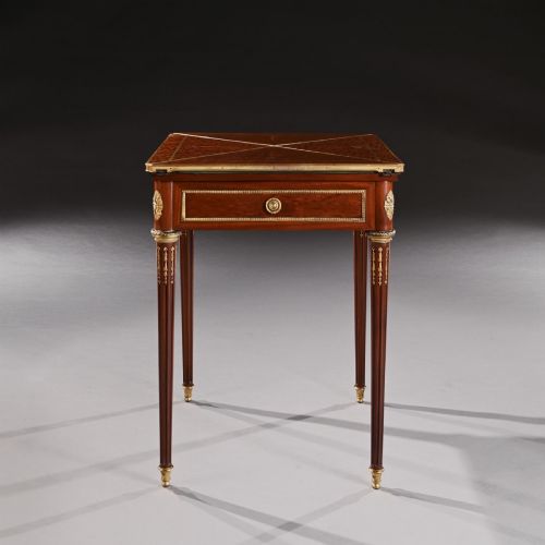 fig 1. A late 19th-century mahogany envelope card table featuring fluted tapered legs, gilt-bronze mounts, and a single frieze drawer.