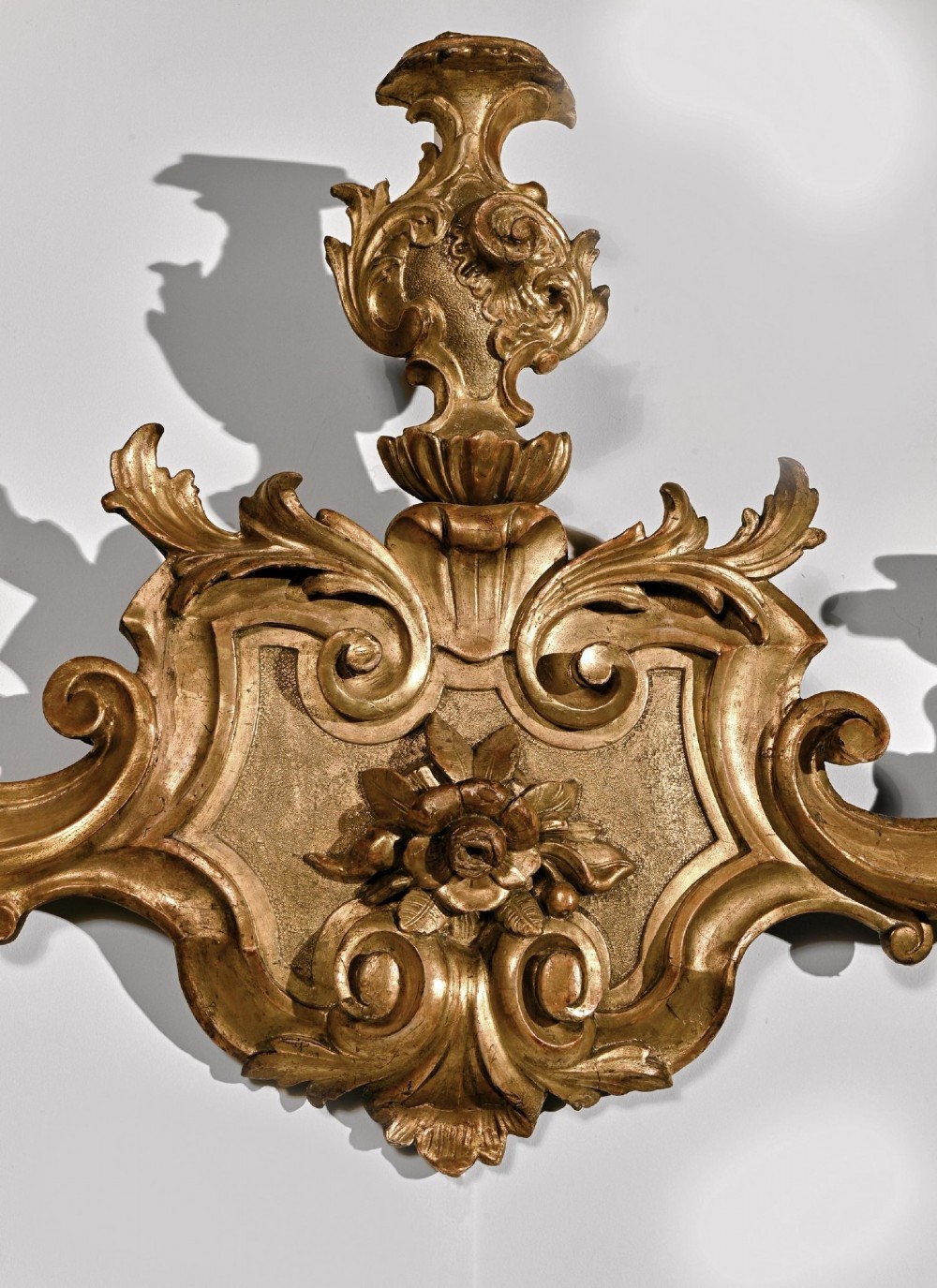 A pair of 18th-century Venetian carved giltwood wall sconces decorated with Rococo scrollwork, central urn finials, and candle nozzles. View VII