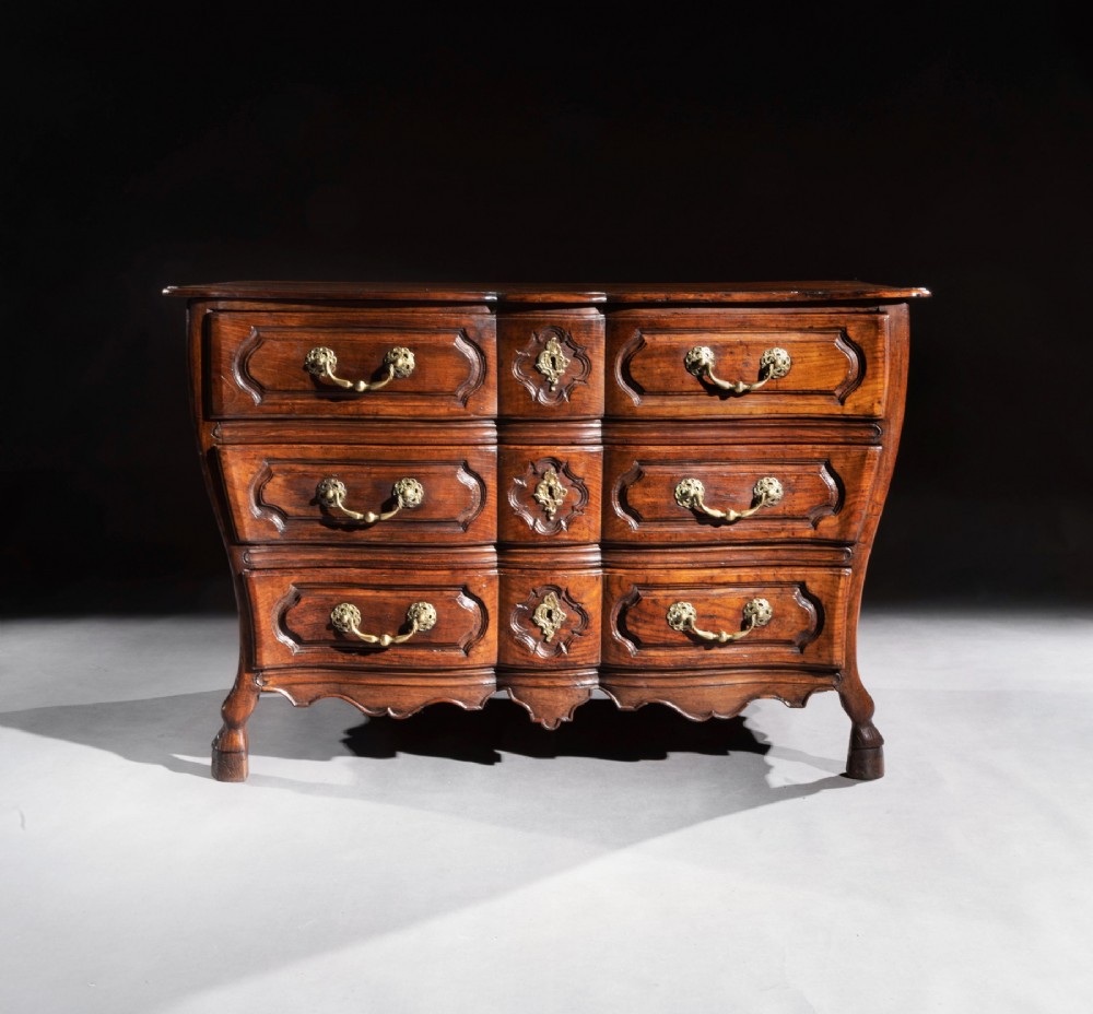 A mid-18th-century Louis XV French provincial chestnut commode featuring a bombe profile, three carved drawers, and brass hardware. View VIII
