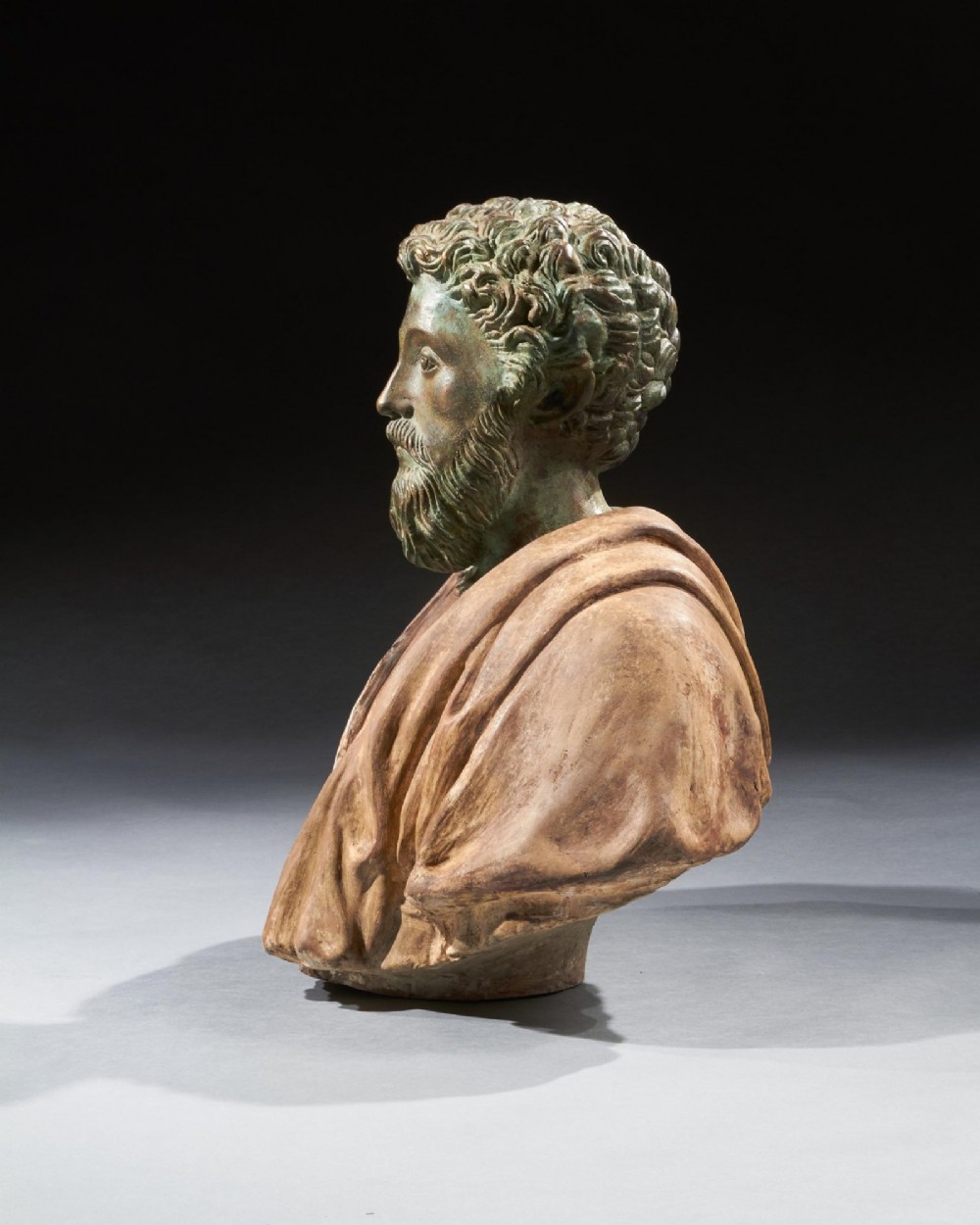 A pair of late nineteenth-century terracotta portrait busts depicting Roman Emperors Marcus Aurelius and Caracalla with verdigris-tinted heads and draped garments. View IV