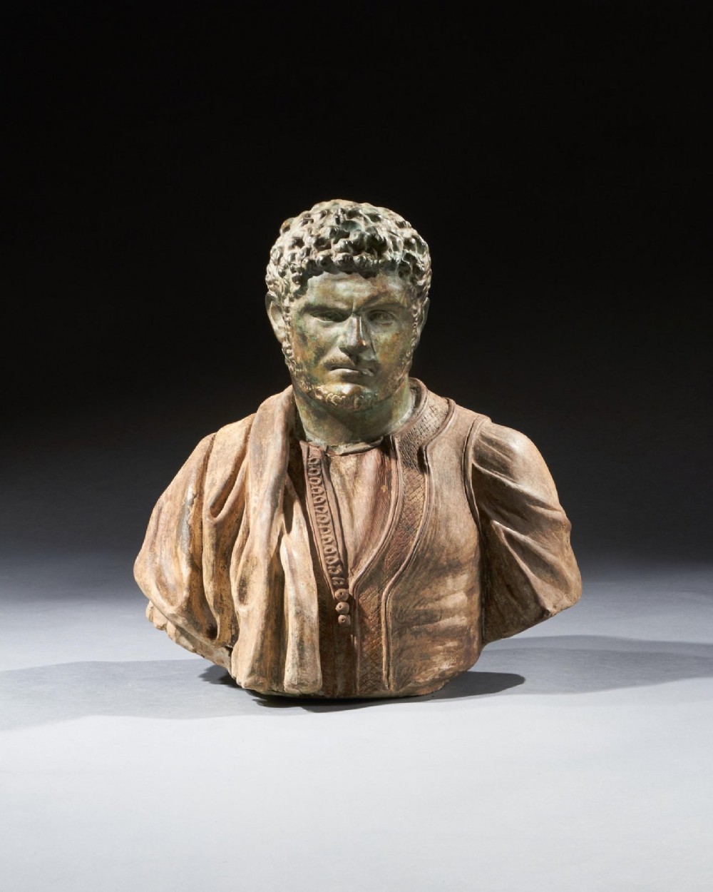A pair of late nineteenth-century terracotta portrait busts depicting Roman Emperors Marcus Aurelius and Caracalla with verdigris-tinted heads and draped garments. View IX