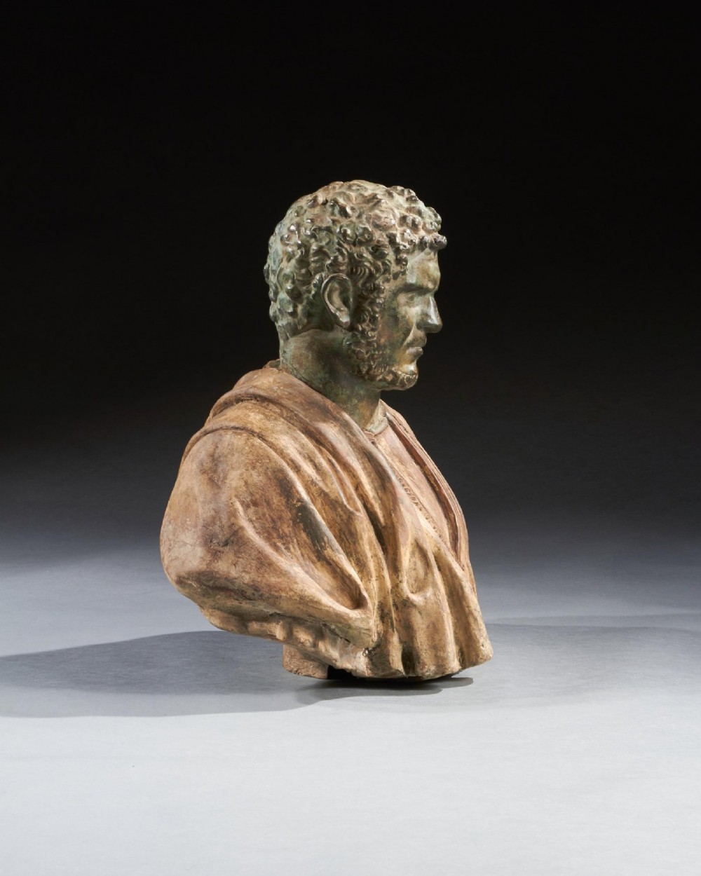 A pair of late nineteenth-century terracotta portrait busts depicting Roman Emperors Marcus Aurelius and Caracalla with verdigris-tinted heads and draped garments. View XII
