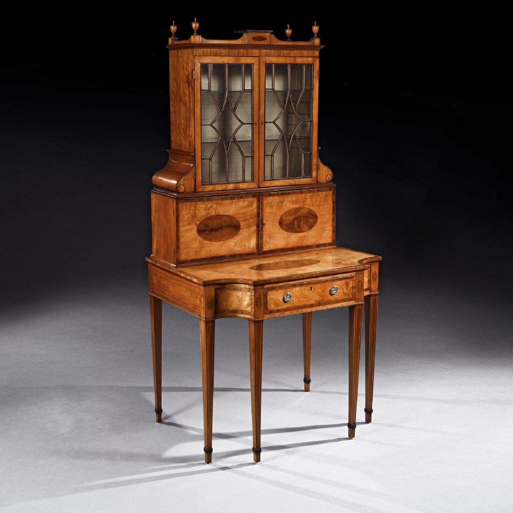 An 18th-century George III satinwood writing cabinet with a glazed upper bookcase, oval inlaid cupboard doors, and slender tapered legs. View II