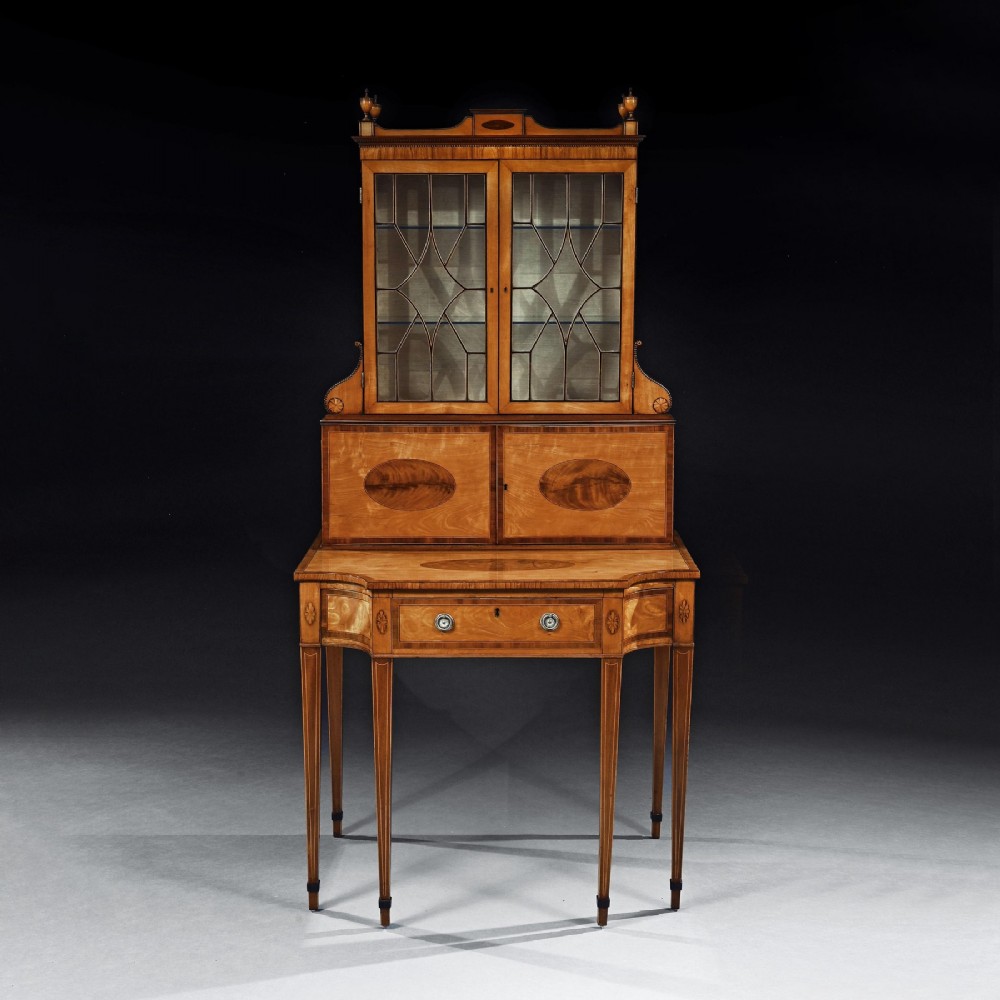 An 18th-century George III satinwood writing cabinet with a glazed upper bookcase, oval inlaid cupboard doors, and slender tapered legs. View III