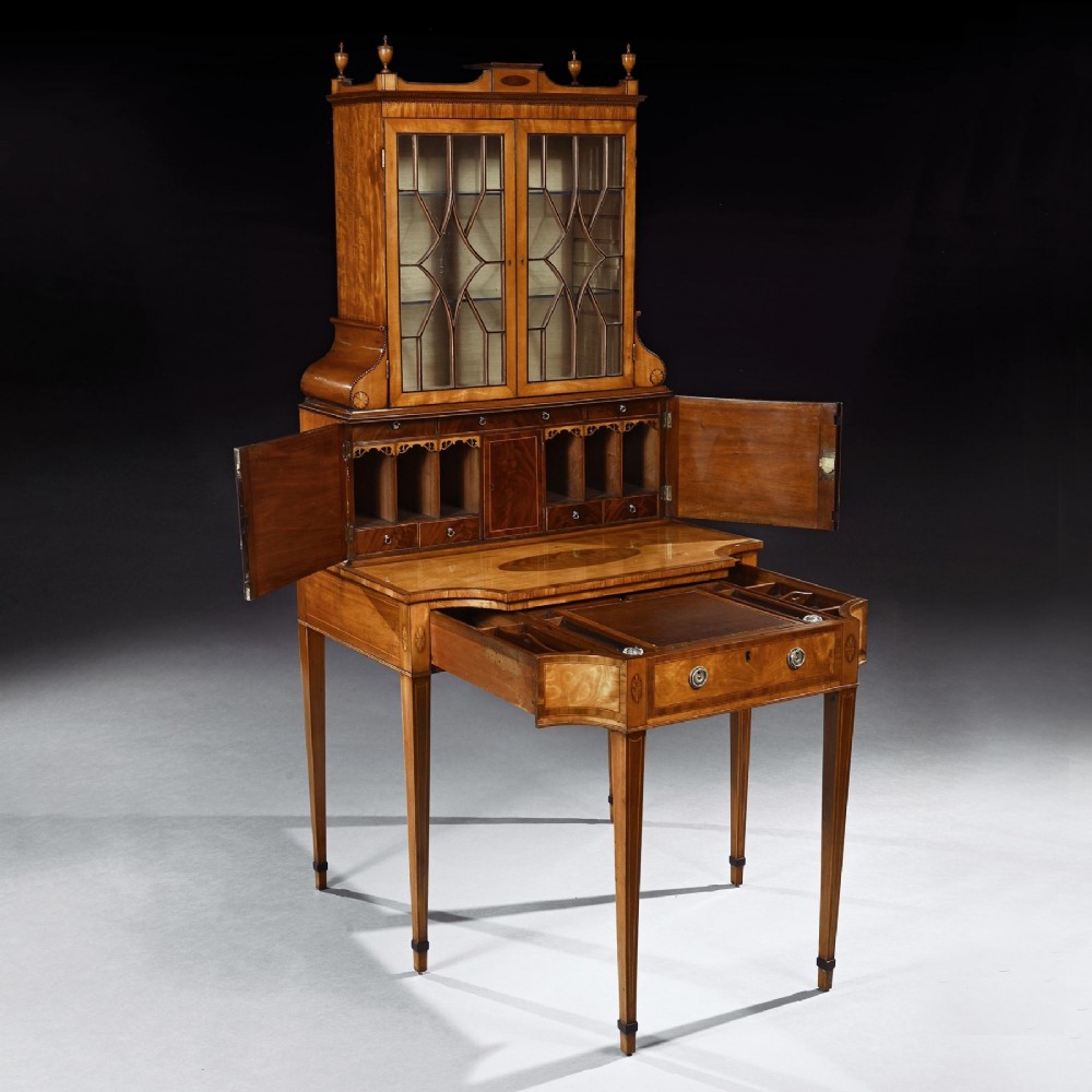 An 18th-century George III satinwood writing cabinet with a glazed upper bookcase, oval inlaid cupboard doors, and slender tapered legs. View IV