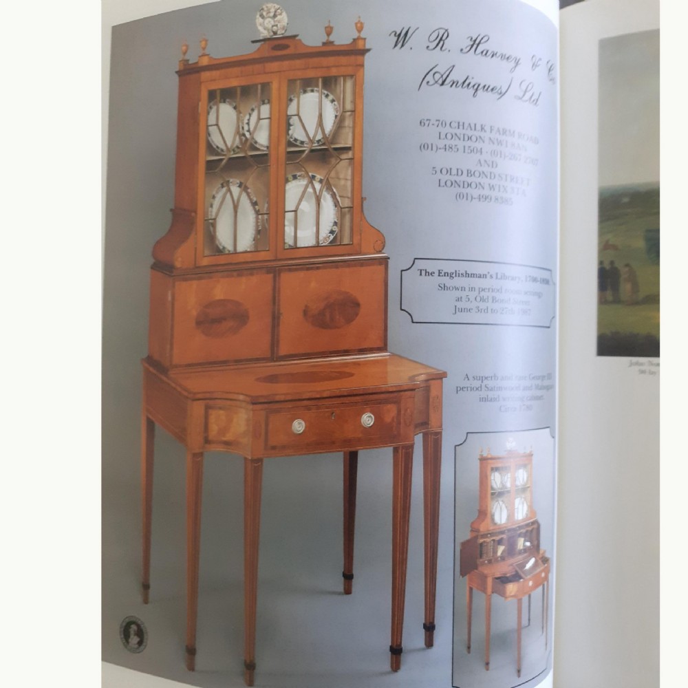 An 18th-century George III satinwood writing cabinet with a glazed upper bookcase, oval inlaid cupboard doors, and slender tapered legs. View X