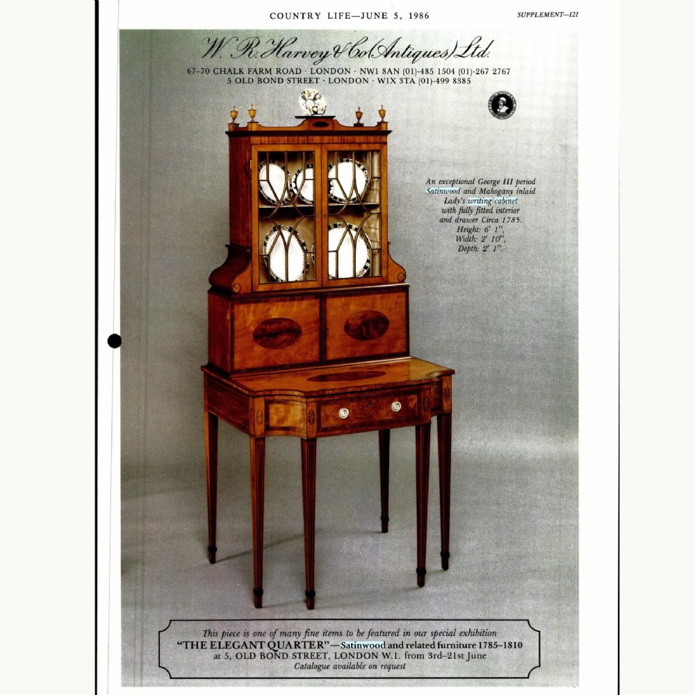 An 18th-century George III satinwood writing cabinet with a glazed upper bookcase, oval inlaid cupboard doors, and slender tapered legs. View XI