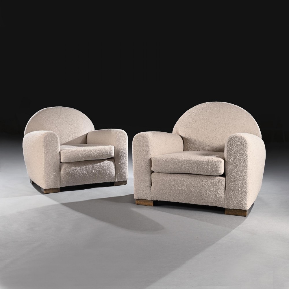 A pair of mid-twentieth-century French club armchairs upholstered in cream boucle fabric with rounded backrests and low wooden block feet. View III