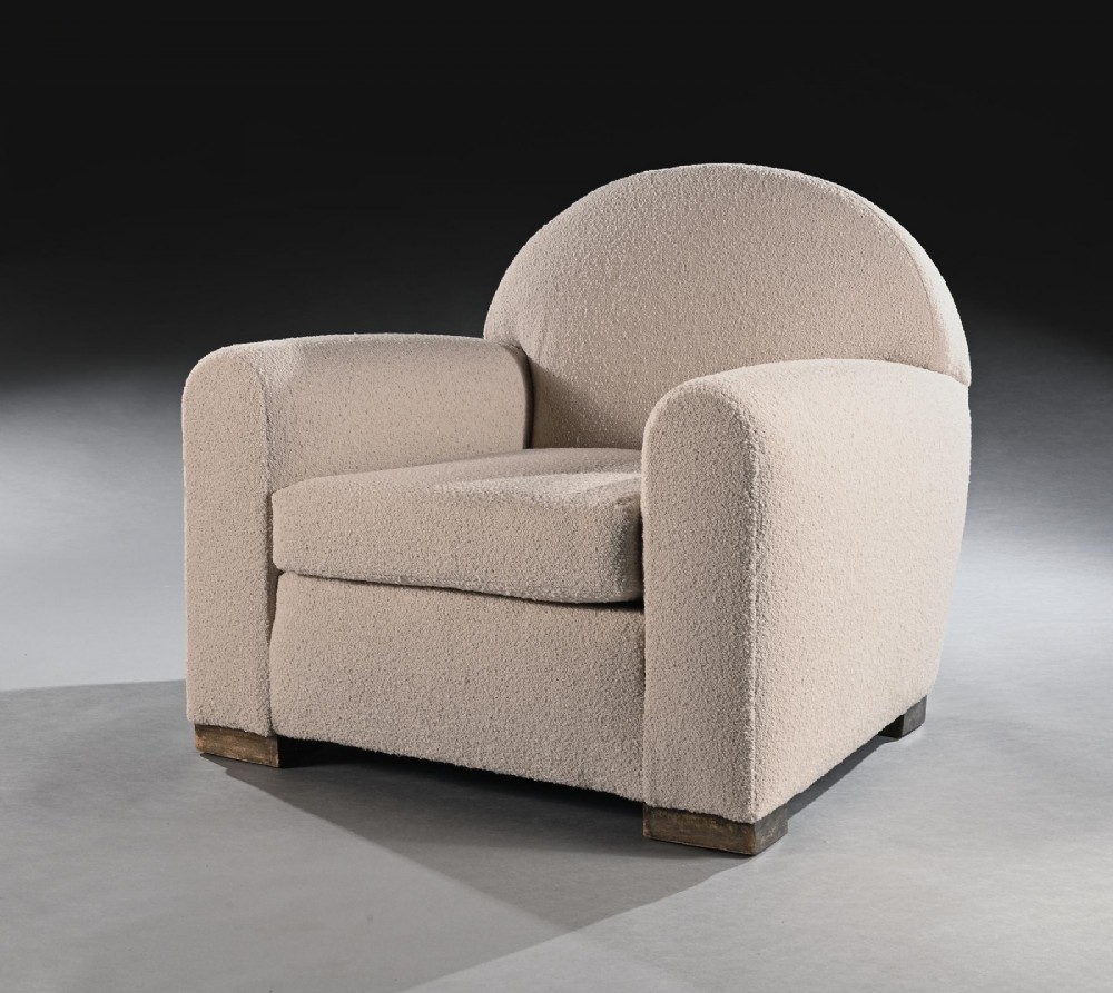 A pair of mid-twentieth-century French club armchairs upholstered in cream boucle fabric with rounded backrests and low wooden block feet. View VI