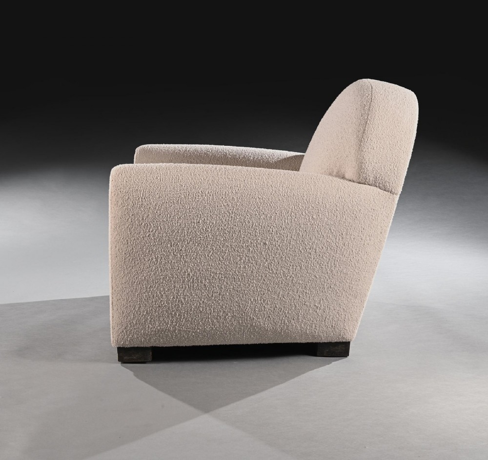 A pair of mid-twentieth-century French club armchairs upholstered in cream boucle fabric with rounded backrests and low wooden block feet. View VII