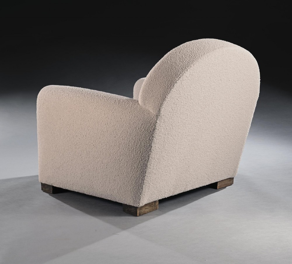 A pair of mid-twentieth-century French club armchairs upholstered in cream boucle fabric with rounded backrests and low wooden block feet. View VIII