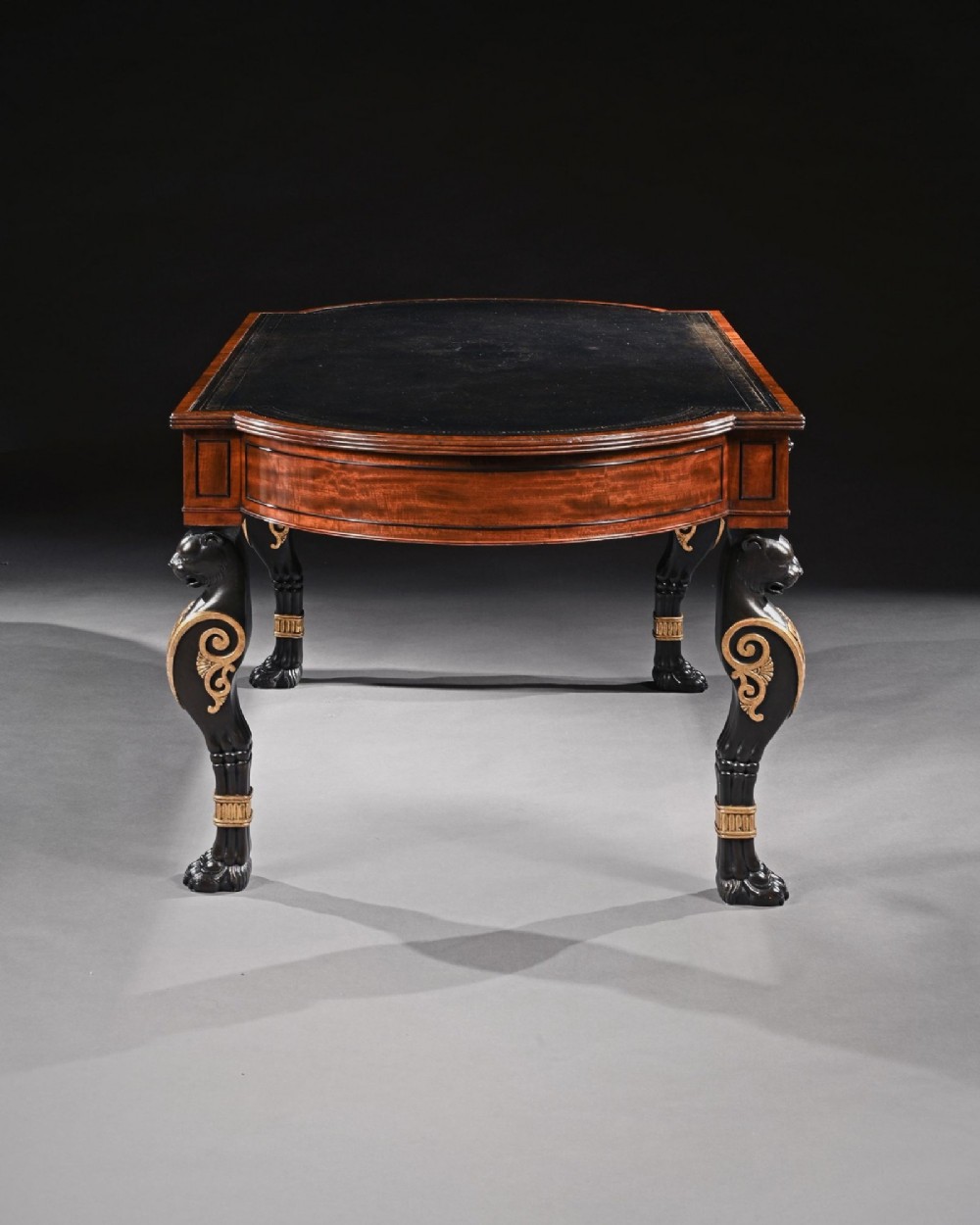 A Regency mahogany partners writing table with a dark leather inset top, frieze drawers, and ebonised lion monopodia legs adorned with gilt highlights. View III