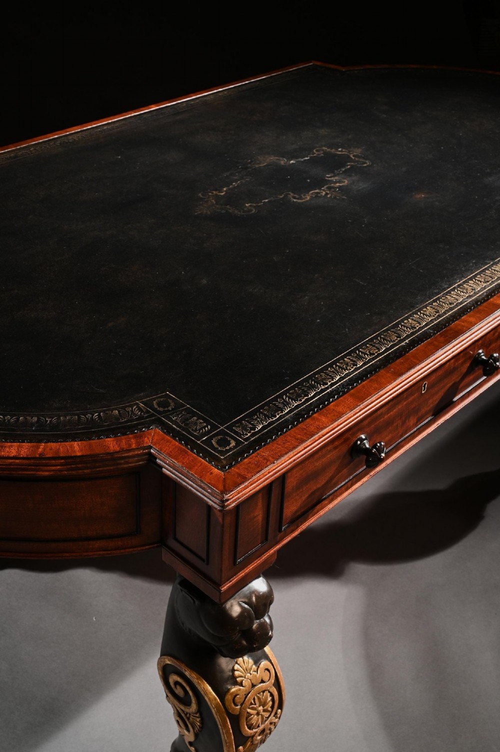A Regency mahogany partners writing table with a dark leather inset top, frieze drawers, and ebonised lion monopodia legs adorned with gilt highlights. View VI