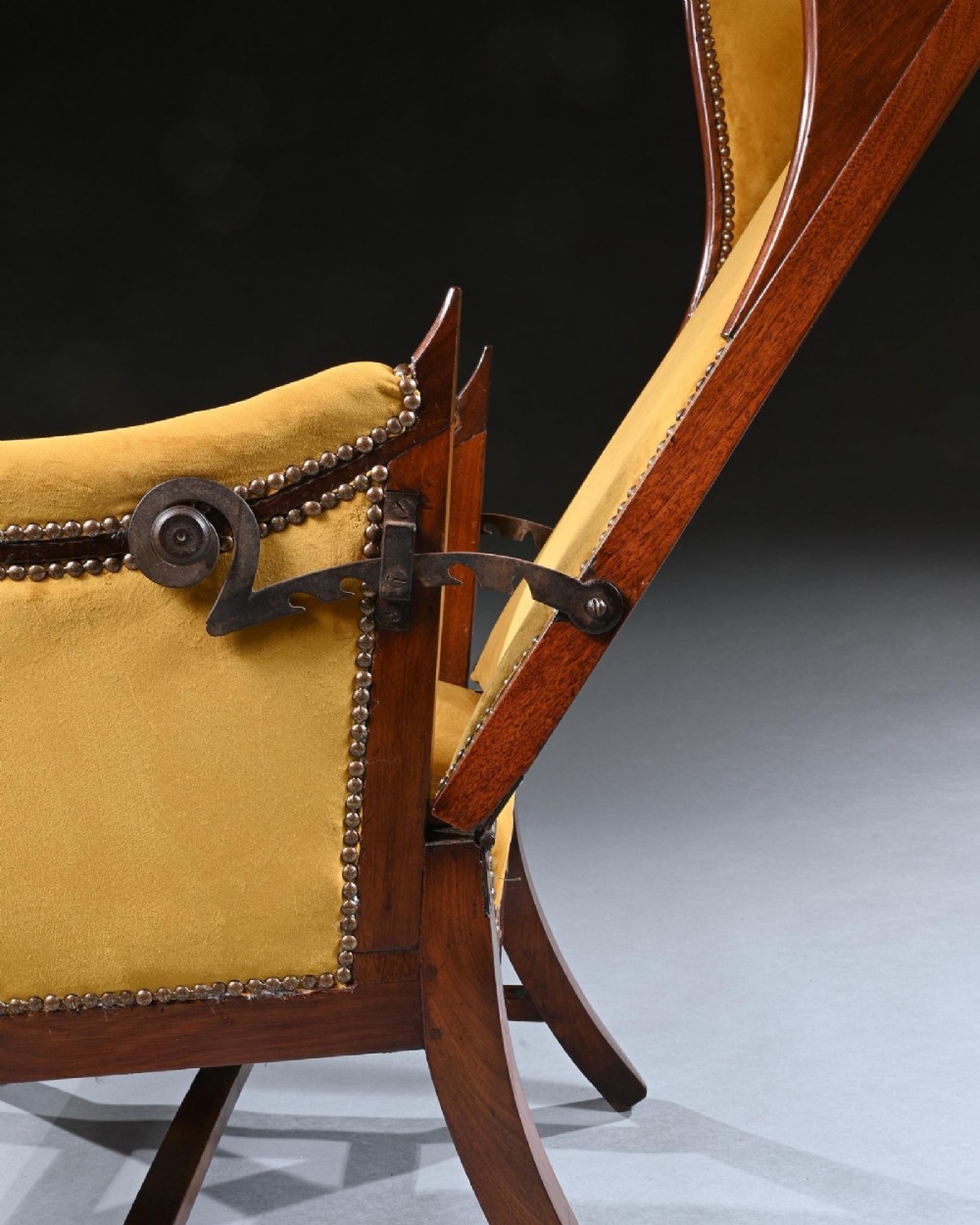 A French Empire style reclining wing back armchair with dark mahogany framing, brass stud detailing, and yellow velvet upholstery. View III