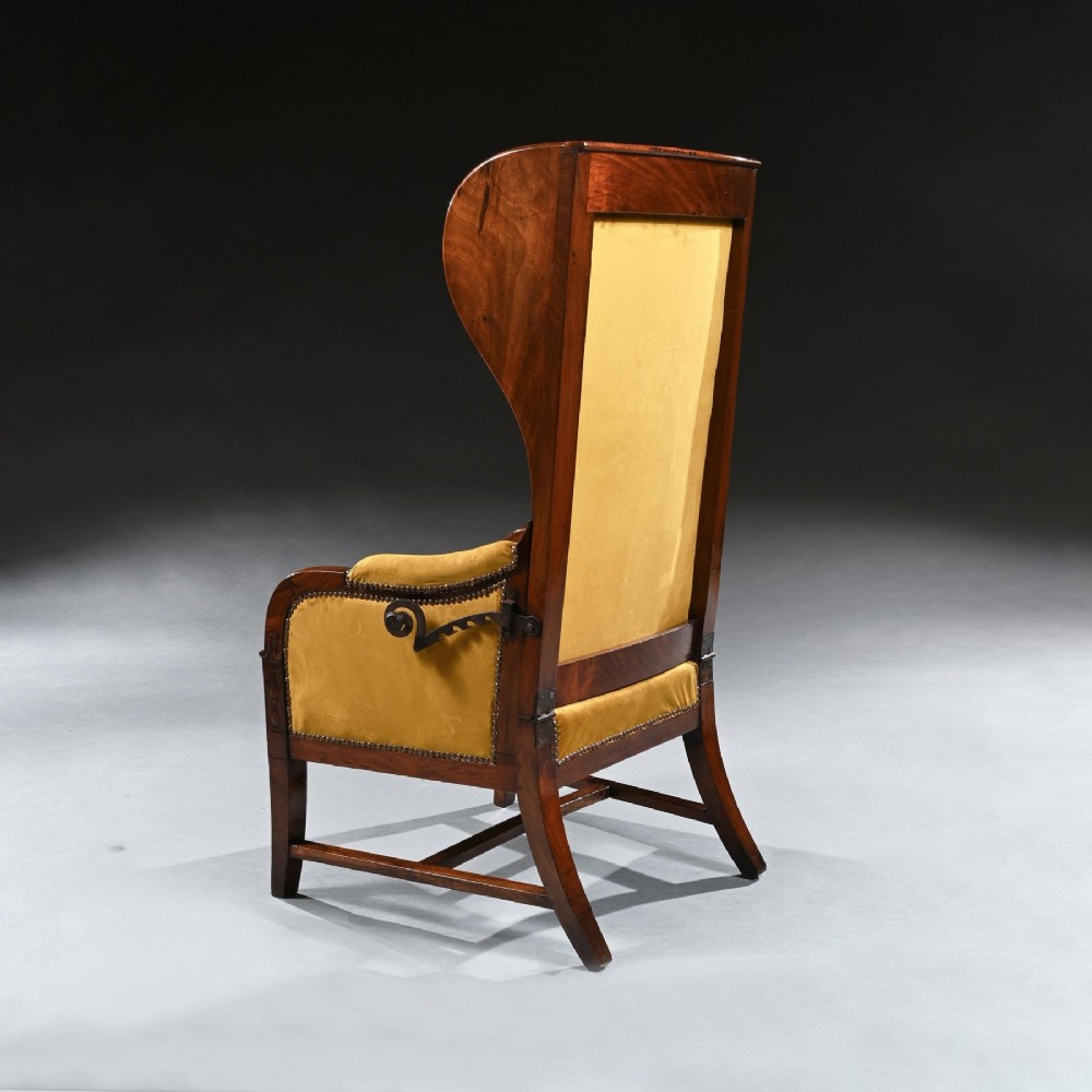 A French Empire style reclining wing back armchair with dark mahogany framing, brass stud detailing, and yellow velvet upholstery. View VII