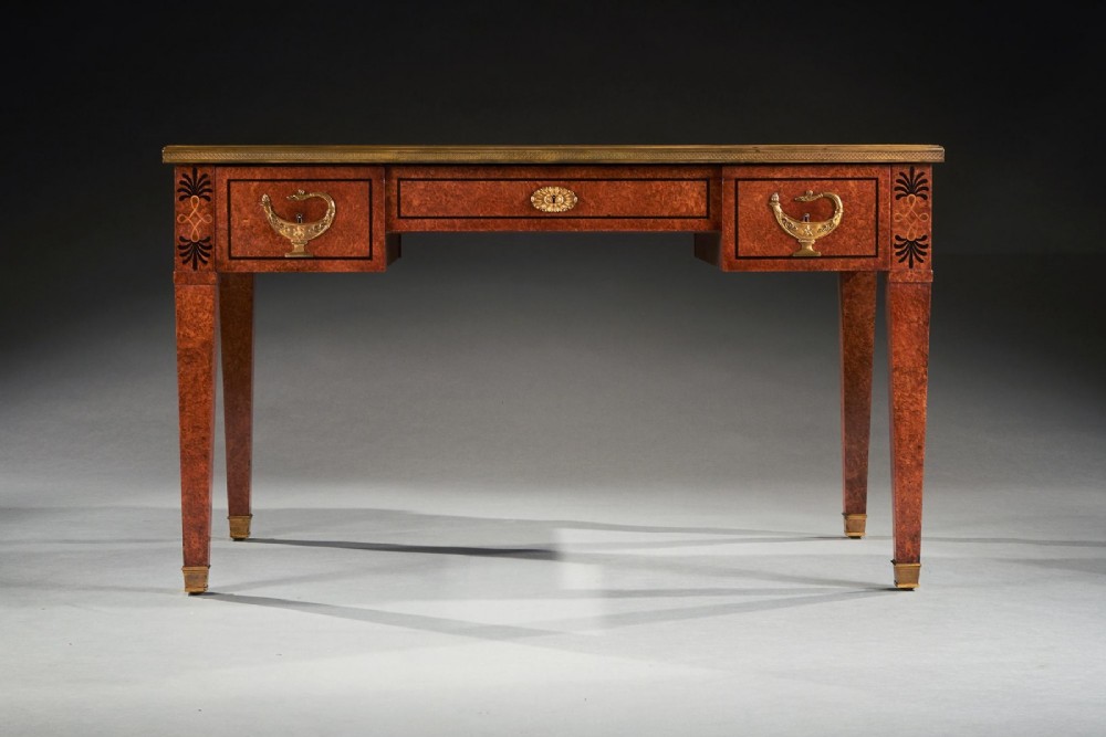 A French Neoclassical style amboyna writing table featuring gilt bronze mounts, three front drawers, and tapered square legs. View II