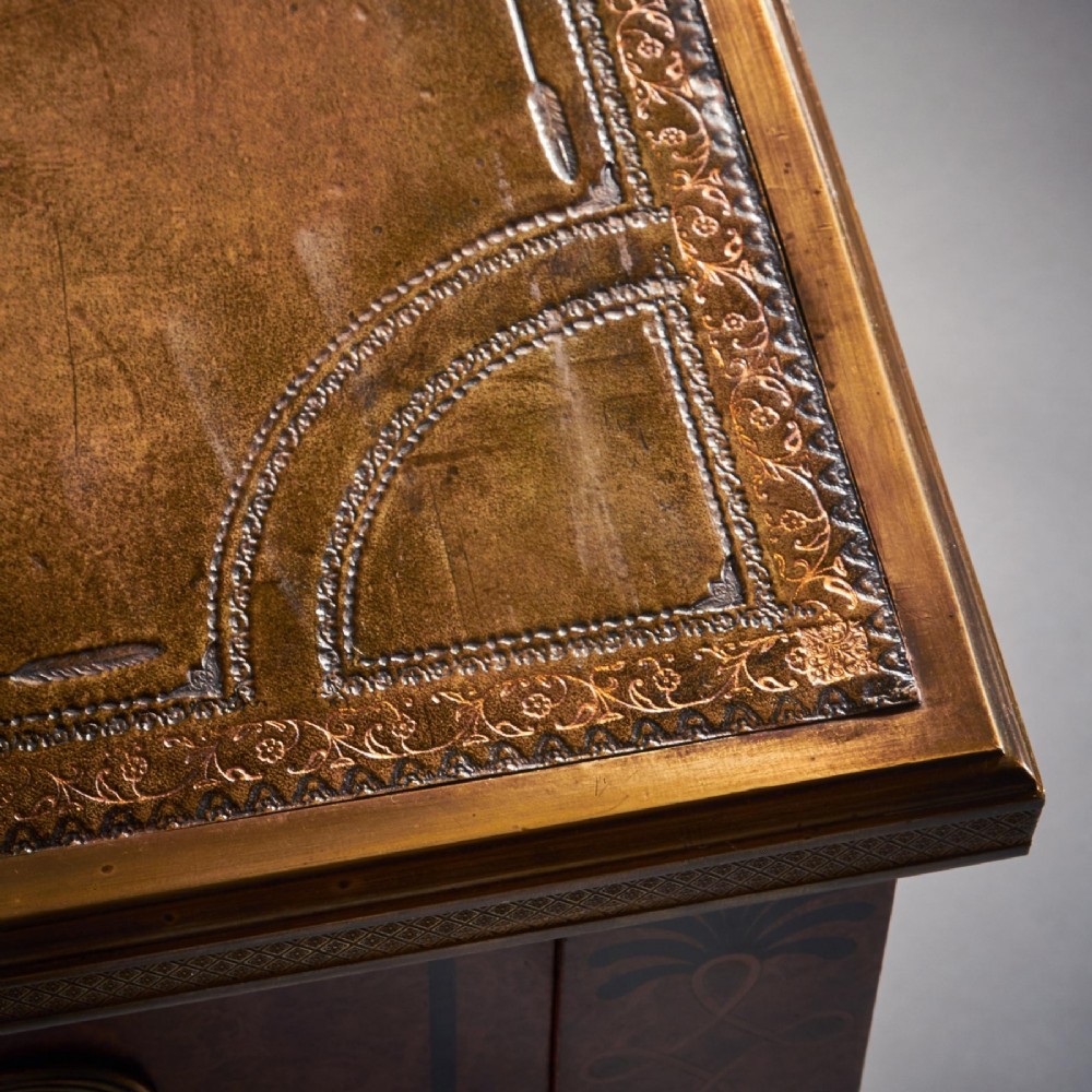 A French Neoclassical style amboyna writing table featuring gilt bronze mounts, three front drawers, and tapered square legs. View VII