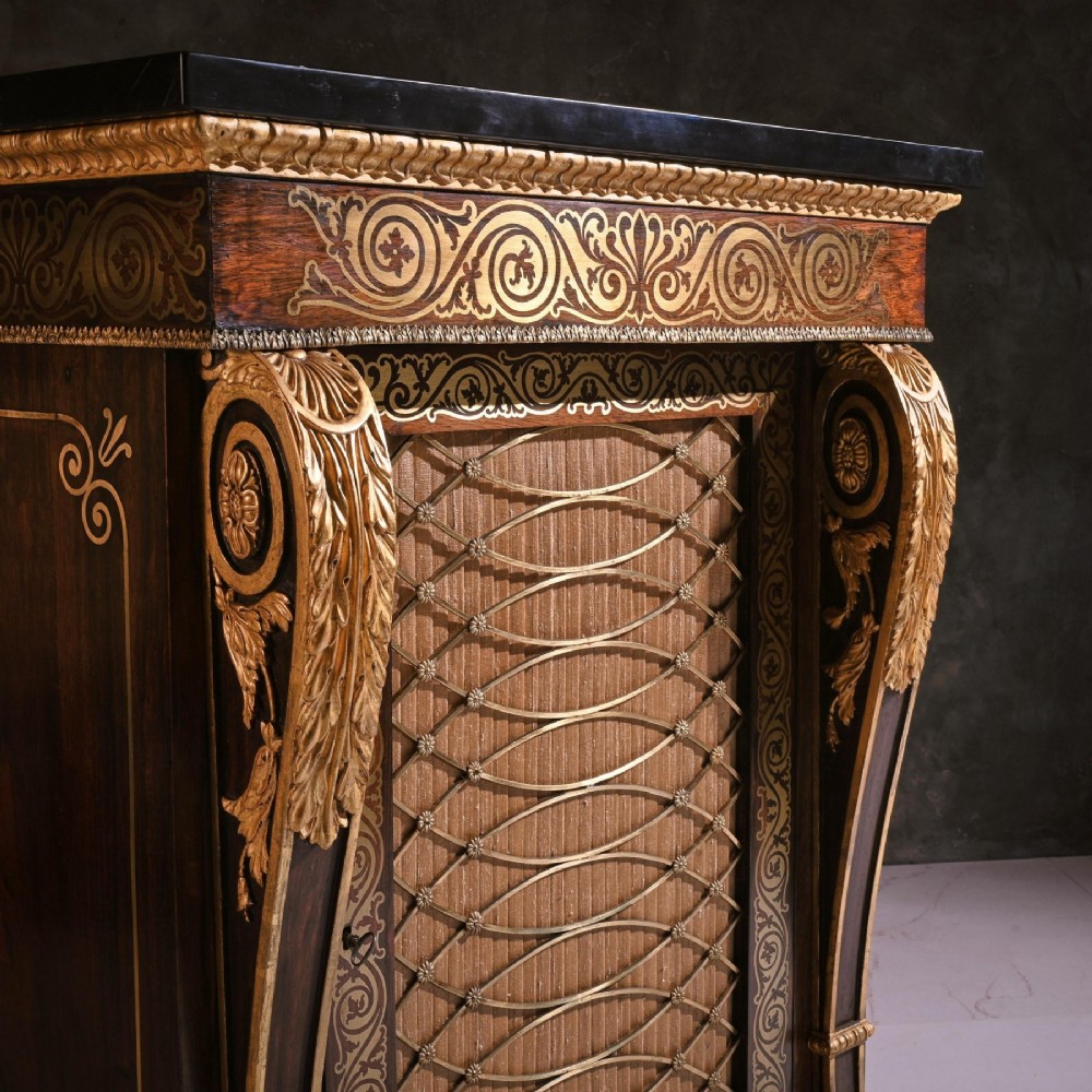 A pair of dark wood Regency side cabinets featuring intricate brass inlaid foliage, gilt corner mounts, brass wire mesh doors, and dark marble tops. View V