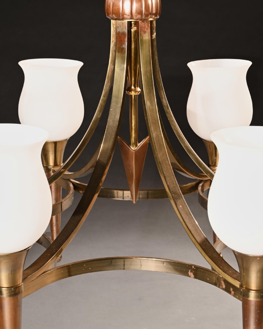A mid-century brass and copper six-arm chandelier featuring a central arrow motif and frosted tulip glass shades. View II