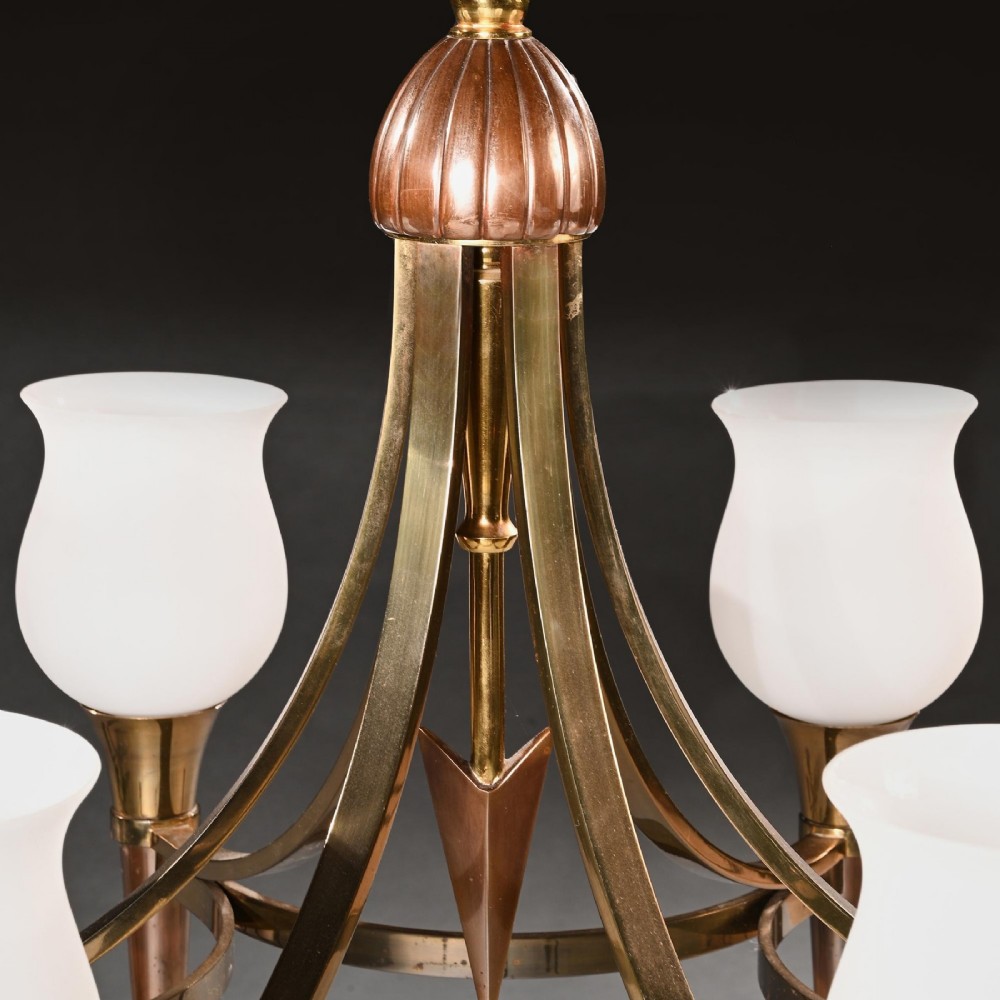 A mid-century brass and copper six-arm chandelier featuring a central arrow motif and frosted tulip glass shades. View IV